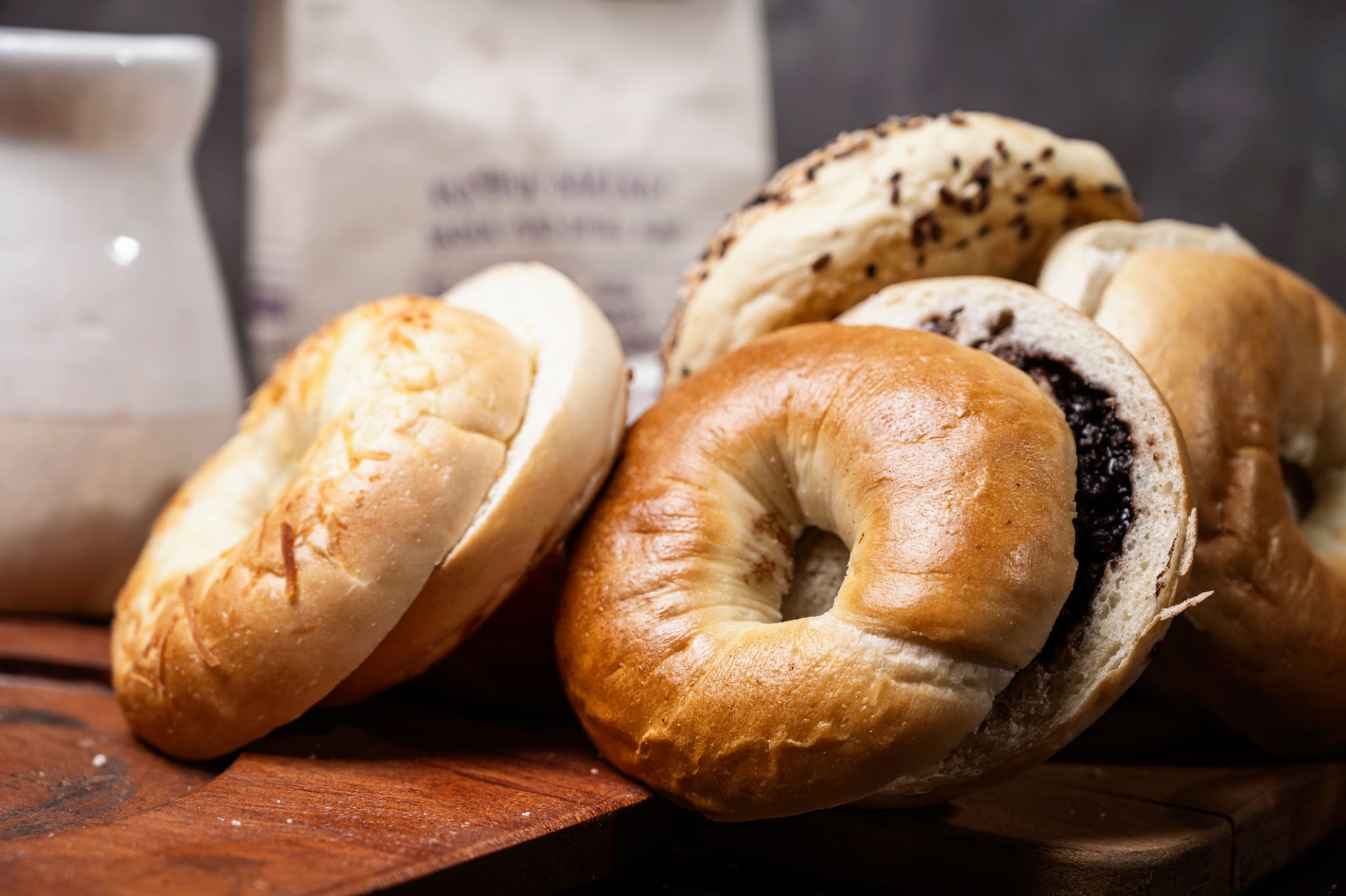 Assorted fresh bagels on a wooden board